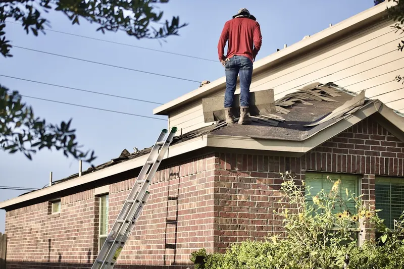 Professional roofer working on a residential roof in Alief